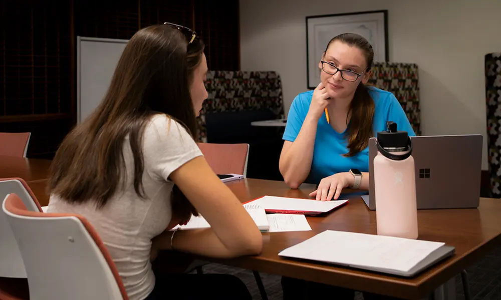 Mental health professional talking to a young woman in an office